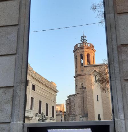 Desde el espejo un cajero en la plaza Sant Roc vemos el reflejo del edificio del Ayuntamiento y del campanario de la iglesia Sant Fèlix.