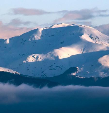 El Puigmal nevado entre nubes.