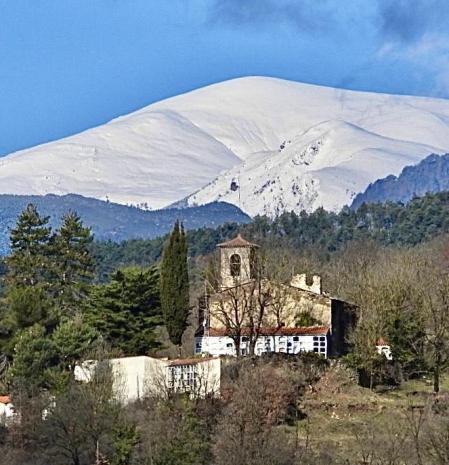 El Puigllançada (2409 metros), nevado, sobre la iglesia del cementerio en Campdevànol (Ripollès).