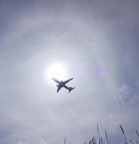 Avión con el halo solar, visto desde la playa de Gavà.