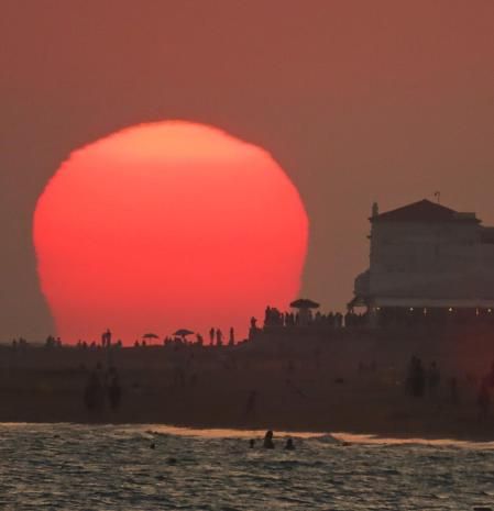 La bruma del sol deformado al atardecer en la playa de la Costilla.