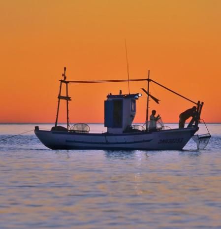 Pesquero faenando al amanecer en la costa de Fuengirola.