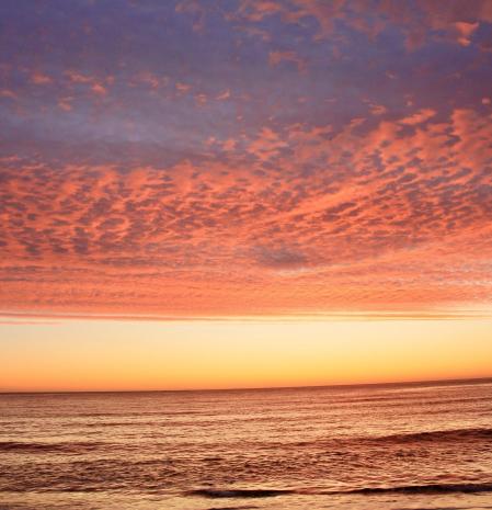 Amanecer de cielo encendido en la playa de La Fosca.
