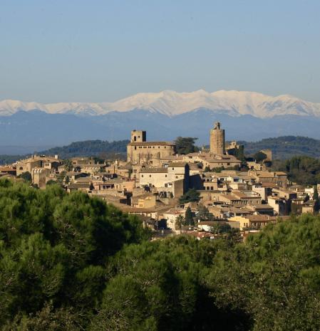 El pueblo de Pals con los pirineos nevados detrás.