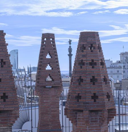 Las chimeneas del Palau Güell de Gaudí, Palau Güell, con el Hotel W, el monumento a Colón y la Torre Jaume I más allá.