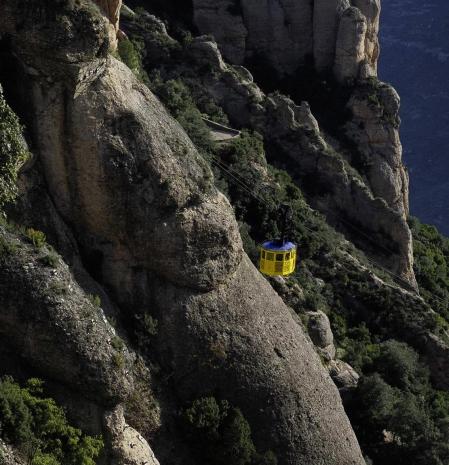 Una de las cabinas amarillas del Aeri sigue su trayecto que conecta la base de la montaña con el monasterio de Montserrat.