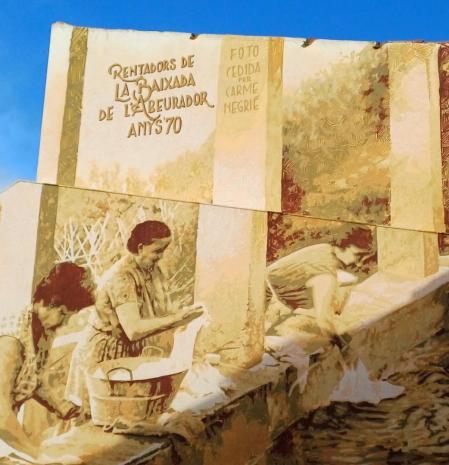 El artista @rocblackblock reprodujo en un mural una fotografía de los años 70 con tres vecinas del pueblo lavando la ropa en los lavaderos de la Baixada de l'Abeurador, también conocidos como Quatre Cantons.