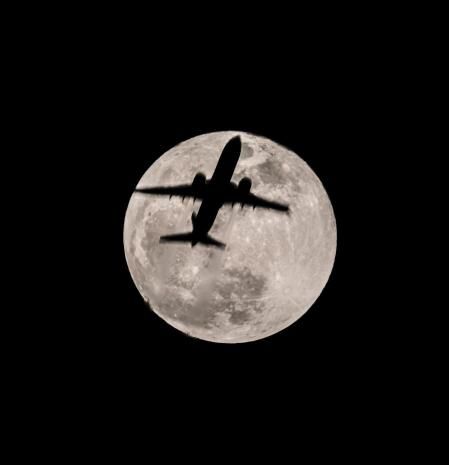 Avión sobrevolando Barcelona con la luna llena del Gusano bien iluminada.