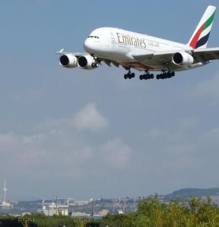 El icono de la aviación , el A380 de Emirates, sobrevolando símbolos de Montjuïc con el Estadi, el Palau Sant Jordi y la Torre Calatrava, en su aproximación al aeropuerto de El Prat, visto desde El Mirador de los Aviones.