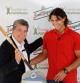 El ex tenista Manolo Santana sostiene una raqueta junto al número uno mundial, Rafa Nadal, en el Real Club de Tenis de Barcelona