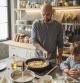 Father with two kids preparing pancakes at home