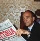 (Original Caption) Rome, Italy: Giorgio Almirante, secretary of the neofacist Italian Social Movement (MSI), sits behind his desk smilingly reading newspaper headlines about his party's gains in local elections which involved seven million votes.