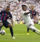 Real Madrid's Vinicius Junior vies for the ball with Barcelona's Jules Kounde, left, during a Spanish La Liga soccer match between Real Madrid and Barcelona at the Santiago Bernabeu stadium in Madrid, Sunday, Oct. 16, 2022. (AP Photo/Manu Fernandez)