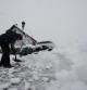 Una persona intenta limpiar de nieve para poder sacar su vehículo de una calle de la localidad de Espinal donde una intensa nevada caída durante la jornada de este lunes cubre completamente la carretera