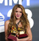 Shakira poses in the press room with the awards for song of the year and best pop song for 