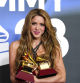 Shakira poses in the press room with the awards for song of the year and best pop song for 