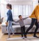 Small boy pulling his parents in the living room who are about to get a divorce.