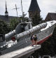 Children walk next to a Russian Navy boat at a World War II memorial monument in Kaliningrad, one of the host cities of the Russia 2018 World Cup football tournament, on June 19, 2018. / AFP PHOTO / Ozan KOSE