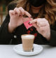 A young woman having a coffee wearing a protective face mask