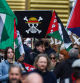 TOPSHOT - Protestors hold flags including a One Piece pirate flag (C) during a demonstration in Lille, northern France, on October 2, 2025, as part of a nation-wide day of strike called by France's eight biggest workers unions for 