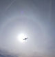 Avión en el halo solar, visto desde la playa de gavà.