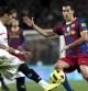 Busquets y Cáceres pugnan por un balón en el encuentro Barça-Sevilla