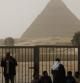 Guías turísticos egipcios y militares aguardan a las puertas de las pirámides de Giza que permanecen cerradas a los turistas