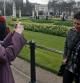 Dos mujeres se fotografían ante el Buckingham Palace durante un 'tour' por Londres que descubre los secretos de la próxima boda real