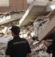 Dos agentes de la policía observan las ruinas de un edificio en Lorca.