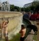 Jóvenes acampados en la plaza Catalunya se bañan en la fuente.