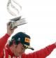 El piloto asturiano Fernando Alonso, tercero en Monza, levanta el trofeo en el podio