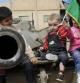 Niños libios sentados encima de un tanque sostienen una bandera de Libia, en Misrata