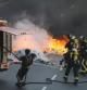 Los bomberos apagan un incendio en una calle de Barcelona durante la huelga del 29-M