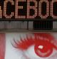 Un cartel de un anuncio publicitario se puede ver por debajo de un tablón de mensajes que se anuncia el precio de Facebook en su salida a bolsa en Times Square