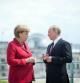 La canciller alemana, Angela Merkel, y el presidente ruso, Vladimir Putin, conversan durante la visita oficial del mandatario a Alemania