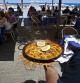 Un camarero se dispone a servir una paella en un chiringuito de playa en Barcelona