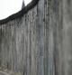 Un turista pasea a lo largo de los restos conservados del muro de Berlín junto al río Spree.