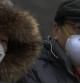Una pareja camina portando unas máscaras para protegerse de los altos índices de contaminación en China