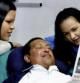 El presidente venezolano Hugo Chávez lee el periódico Granma junto a sus hijas