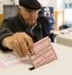 Un hombre deposita su voto en un colegio electoral de Roma