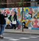Una turista fotografía el mural recién pintado por el proyecto Efímers de Enrotlla't!, en la esquina de Balmes con Provença