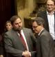 Oriol Junqueras y Artur Mas se dan la mano en el Parlament el pasado enero mientras son observados al fondo de la imagen por el líder de ICV, Joan Herrera