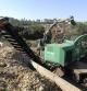 Una máquina tritura madera del bosque de Collserola para utilizarla en una caldera de biomasa.