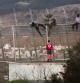 Un trabajador de la Cruz Roja atiende la llegada de inmigrantes que saltan la valla fronteriza de Melilla