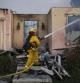 Un bombero trata de apagar las llamas de ua casa situada en la localidad de Carlsbad, en el sur de California