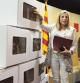 Joana Ortega junto a varios modelos de las urnas encargadas para la votación del 9N