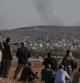 Un grupo de kurdos observa desde una colina en el lado turco de la frontera la ciudad de Kobani, en Siria, asediada por el Estado Islámico