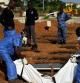 Trabajadores sanitarios de Sierra Leona entierran en una fosa el cadáver de un paciente muerto por ébola