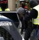 Mossos d'Esquadra escoltan a un detenido en la calle Gran de Sant Andreu durante la operación antiterrorista para desarticular una organización anarquista a la que se atribuyen diversos atentados con artefactos explosivos, que se está llevando a cabo en Barcelona, en la que se han registrado varios centros "okupas" y domicilios particulares, y se han practicado varias detenciones.