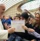El Papa recoge el dibujo con el que le obsequia un niño en una audiencia con empleados en el Vaticano